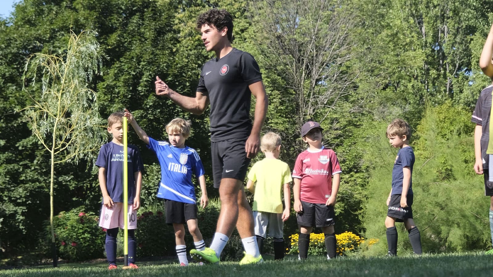 A Footie Elite coach correcting a young player during a small-group session